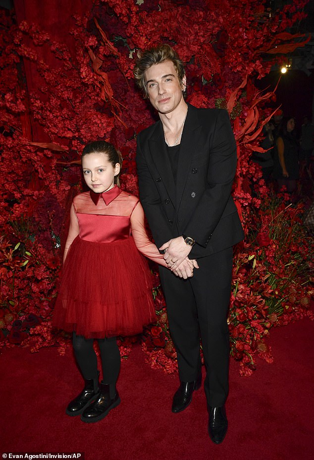 Jeremiah Brent rocked a black double-breasted suit with peaked lapels, though he left it unbuttoned to reveal his casual black shirt underneath. He was joined by his daughter Poppy, who wore a curt red tulle¿and¿satin dress with black stockings