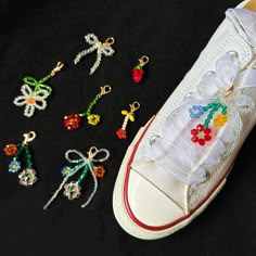 several pairs of shoes with beaded flowers on them and bows tied to the shoelaces