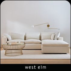 a white couch sitting on top of a hard wood floor next to a coffee table