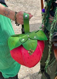 a close up of a person holding a bag with a strawberry on it's side