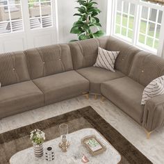 a living room with a large sectional couch and coffee table in front of the window