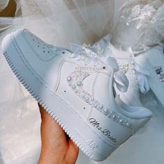 someone is holding up a white nike air force shoe with pearls on the top and bottom