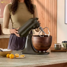 a woman is using a mixer on the counter