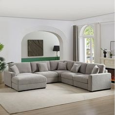 a living room with a large sectional couch in the center and a rug on the floor