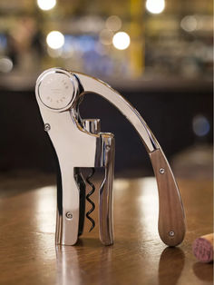 a wine bottle opener sitting on top of a wooden table