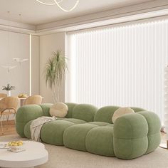 a living room filled with furniture and a large window covered in white sheers next to a dining table