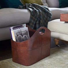 a living room with a couch, chair and magazine holder