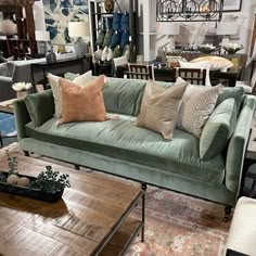 a living room filled with lots of furniture and pillows on top of a wooden table