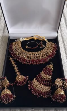 an elaborate necklace and earrings set in a box