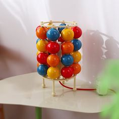 a colorful toy on a table next to a green cup