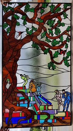 a stained glass window with people and trees