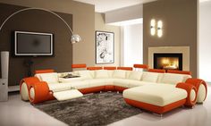 an orange and white sectional sofa in a living room with a tv on the wall