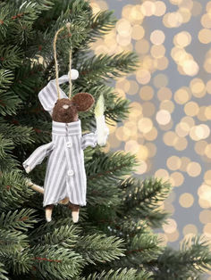 a teddy bear ornament hanging from a christmas tree