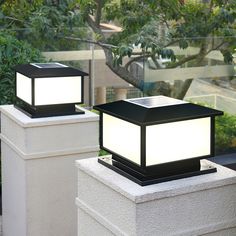 two black and white lights sitting on top of cement blocks