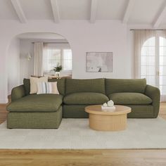 a living room with a large green couch and coffee table in front of the sectional