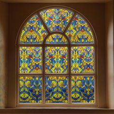 a stained glass window in the corner of a room with blue and yellow flowers on it