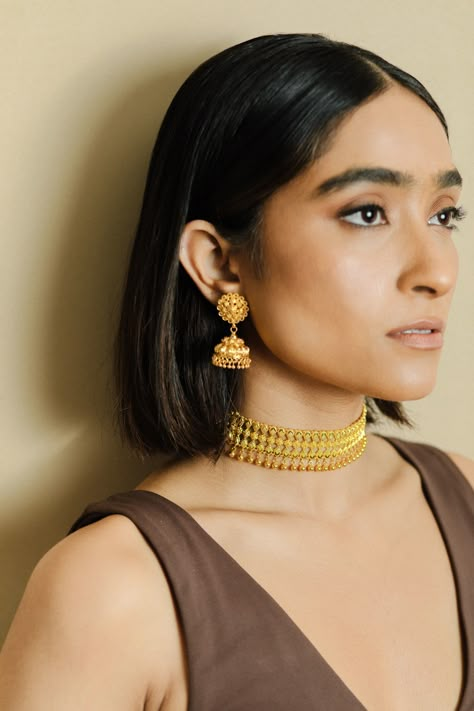 Introducing the timeless elegance of our 22k gold oxidized choker set, perfect for the traditional Indian bride. This stunning set features intricate designs and is handcrafted to perfection, making it a true masterpiece of Indian bridal jewelry. The oxidized finish adds a touch of rustic charm to the set making it perfect for a bride who wants to stand out. The set includes a choker necklace, matching earrings and maang tikka. Shop now and add a touch of traditional charm to your bridal look. Indian Gold Set Design, Indian Gold Jewellery Design Bridal Sets, Elakkathali Necklace, Gold Choker Designs Indian, Gold Jewellery Set For Bride, Neck Pieces Jewelry Indian, Gold Jewellery For Bride, Bridal Gold Jewellery Design Indian, Wedding Gold Jewellery Indian