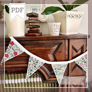 Stitched model of the Winter Floral Bunting cross-stitch pattern by Faby Reilly Designs, displayed on a mantlepiece.