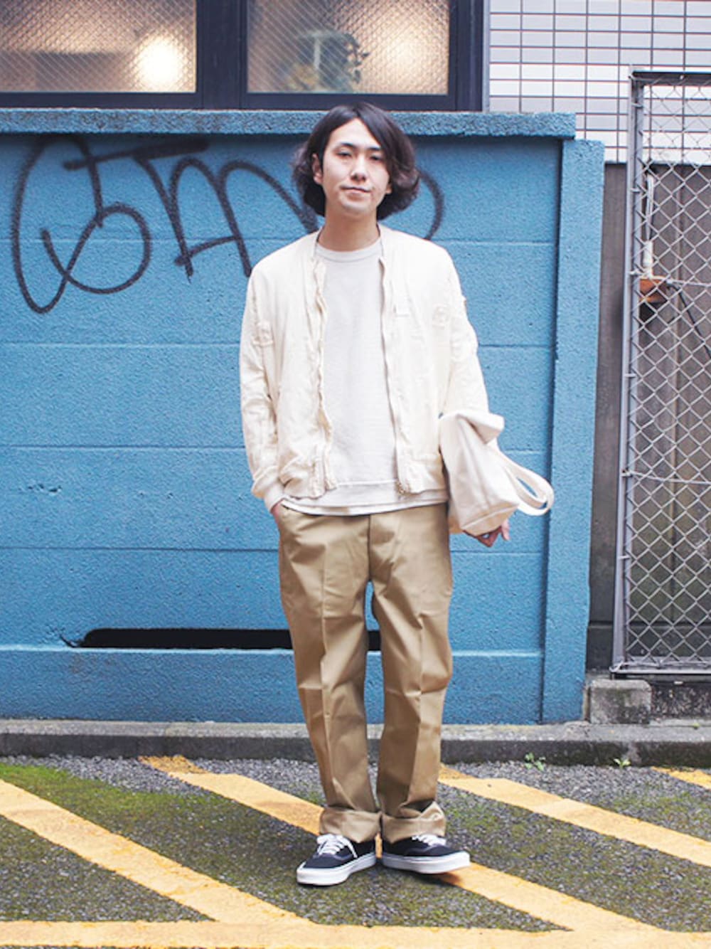 ホワイト系のミリタリージャケット、ホワイト系のニット/セーター、ベージュ系のチノパンツを着用したメンズの春コーディネートの1枚目の写真