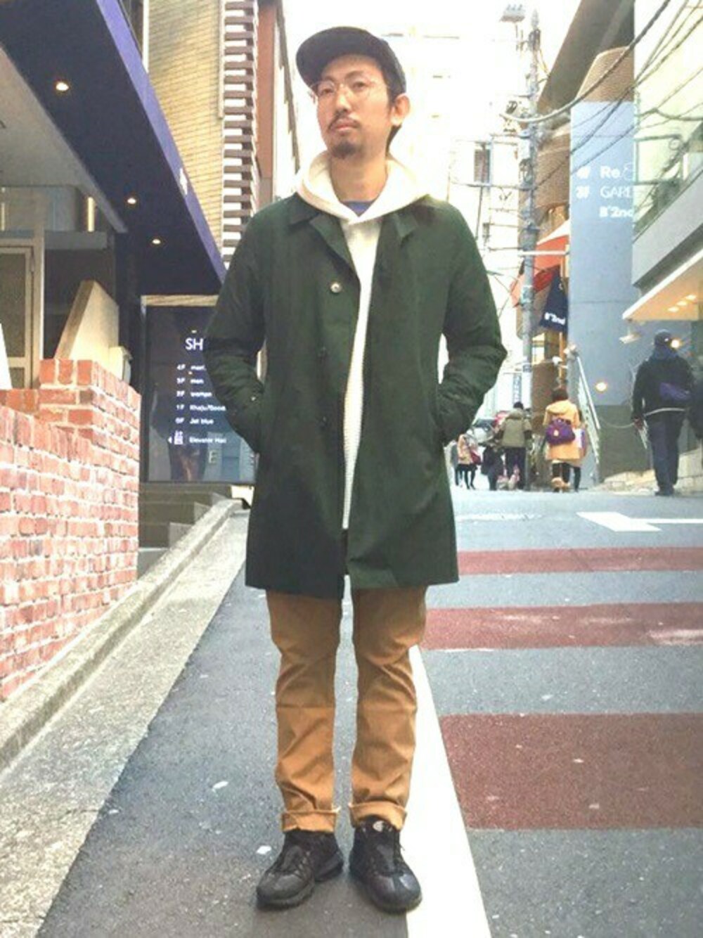 グリーン系のステンカラーコート、ベージュ系のその他パンツを着用したメンズの冬コーディネートの1枚目の写真