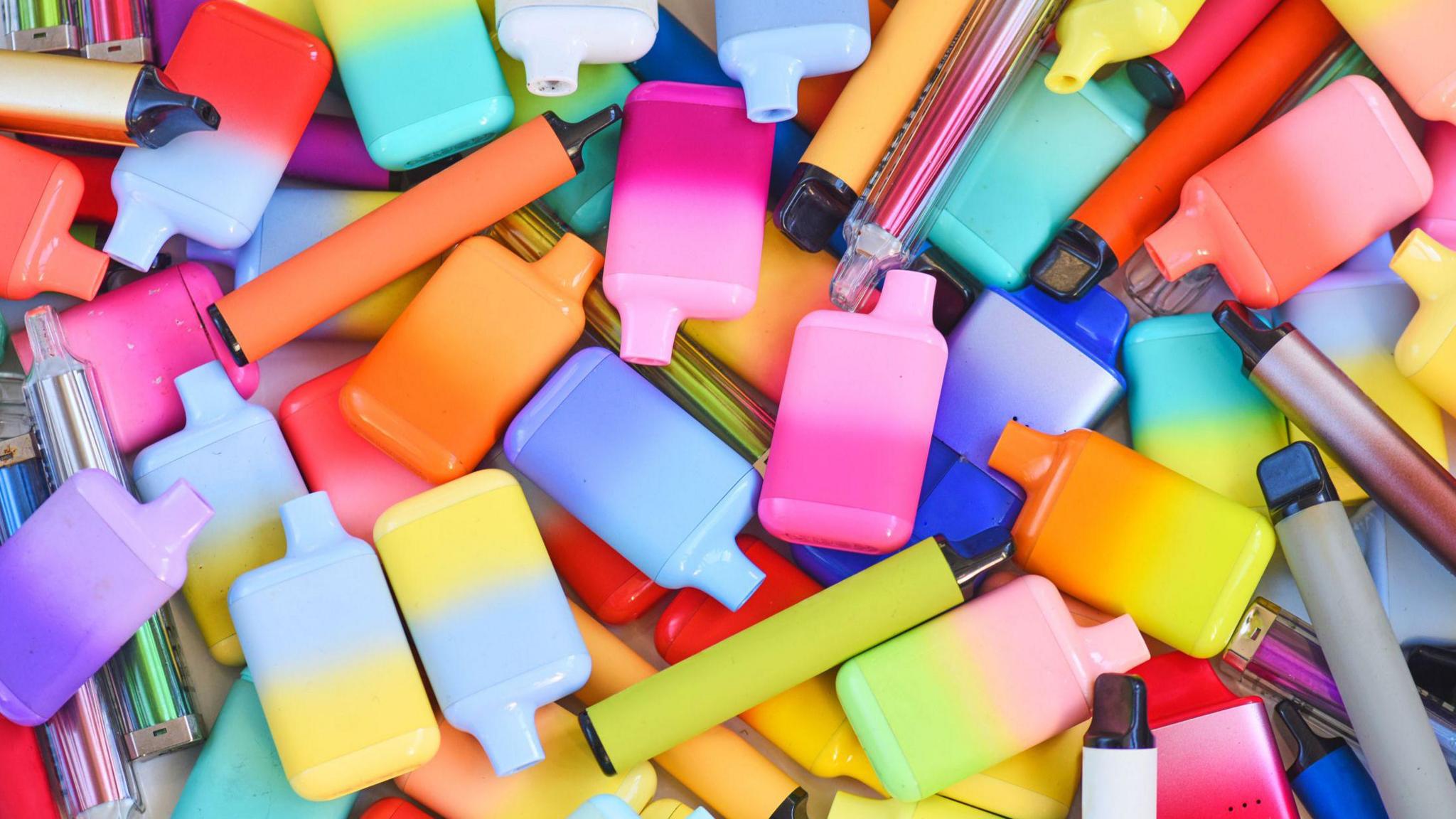 A photo of many bright, multicoloured vapes in different shapes and sizes.