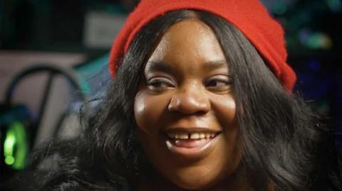 A woman with a red hat smiles