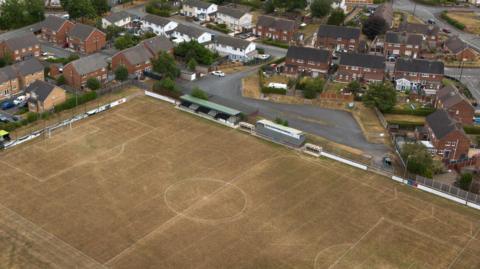 An aerial photograph taken with a drone of a dry football pitch and cricket in Llay, Britain, 27 July 2026.