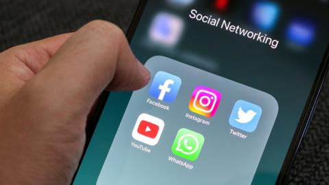 A group of apps on a phone titled 'Social Networking' containing Facebook, Instagram, Twitter, YouTube and Whatsapp