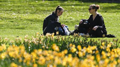 Two women enjoy the sunny weather in St James's Park in London on 6 April 2025