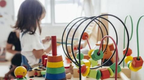 Child playing in a nursery with toys in foreground