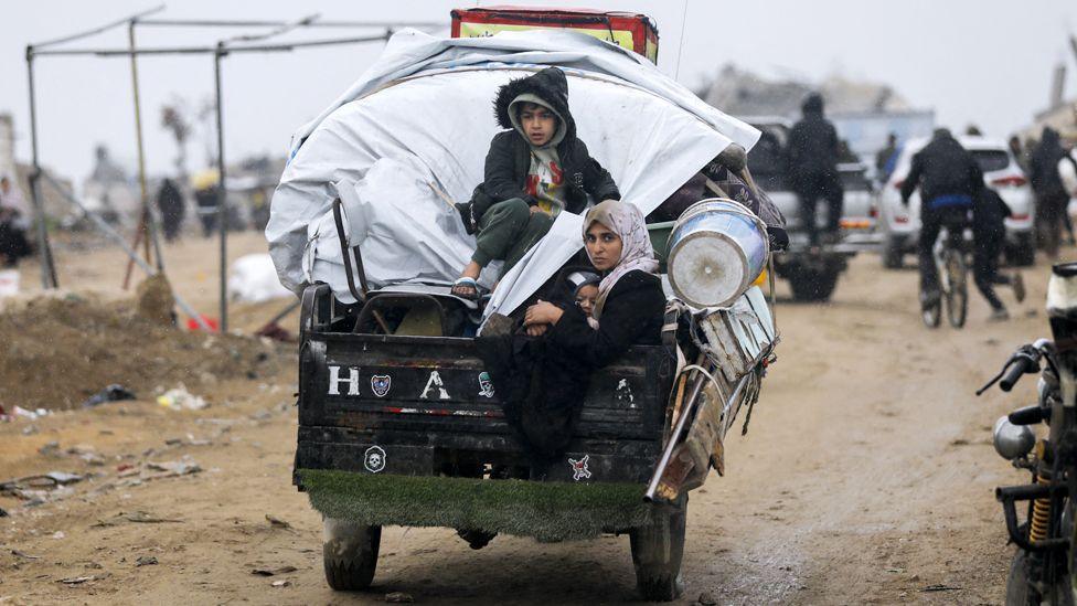 A group of Palestinians ride a cart through debris and destruction in Jabalia, northern Gaza, on February 5, 2025