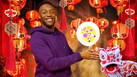 Presenter holding a rattle drum for Chinese New Year