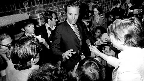 John Stonehouse walking through a crowd of people (Credit: Getty Images)