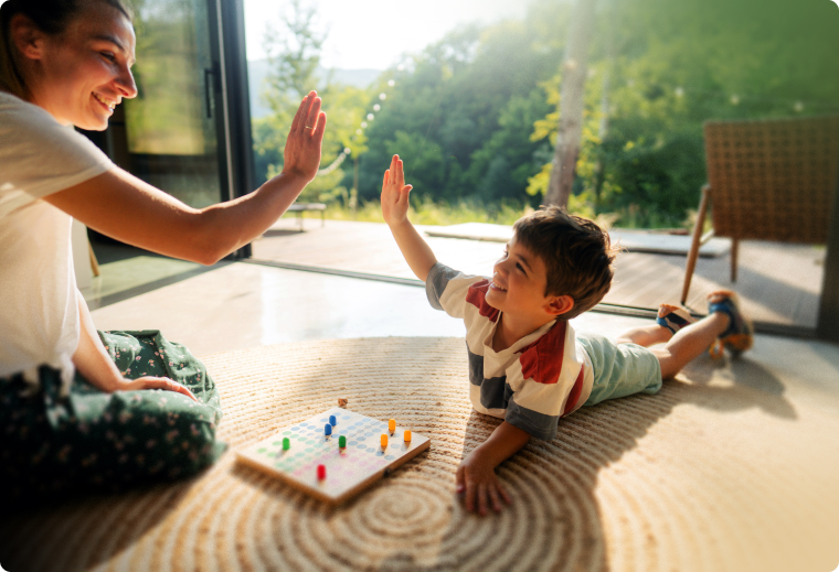 Mother and son playing game on the floor high-fiving