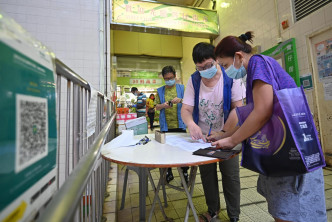 灣仔街市亦有食環署人員看守，協助長者及外傭掃二維碼。