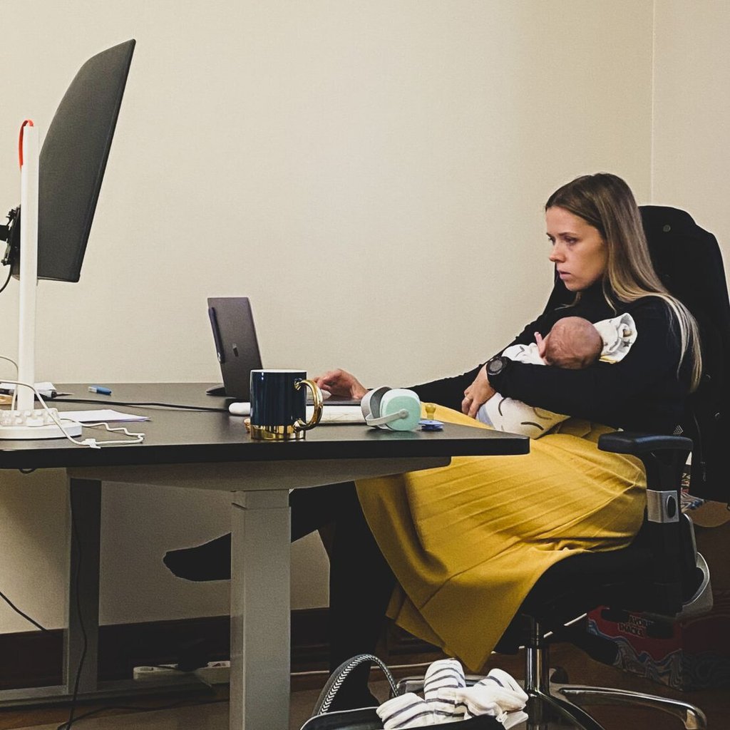 Monika while holding her son during her working hours