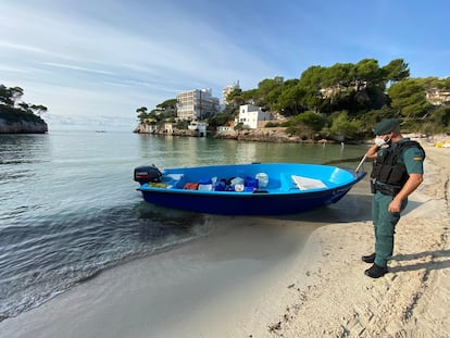 Un agente de la guardia civil, junto a una patera, en una playa de Baleares en una imagen de archivo.