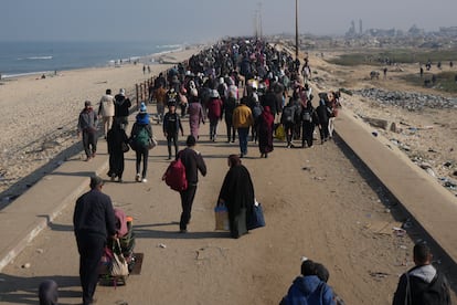 Palestinos desplazados caminan por una carretera para regresar a sus hogares en el norte de la franja de Gaza, este martes.