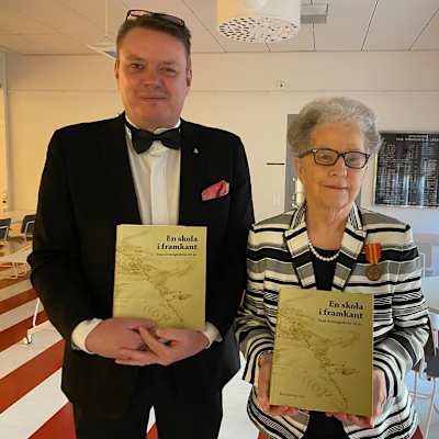 Två personer som håller böcker i händerna.