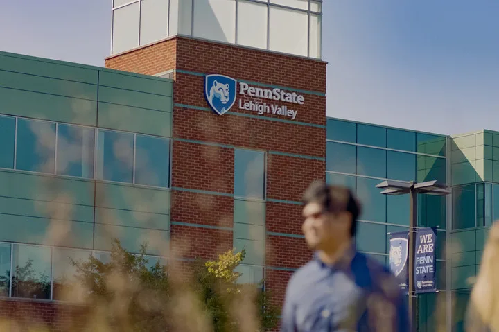 Two people talking to each other on a sidewalk at Penn State Lehigh Valley.