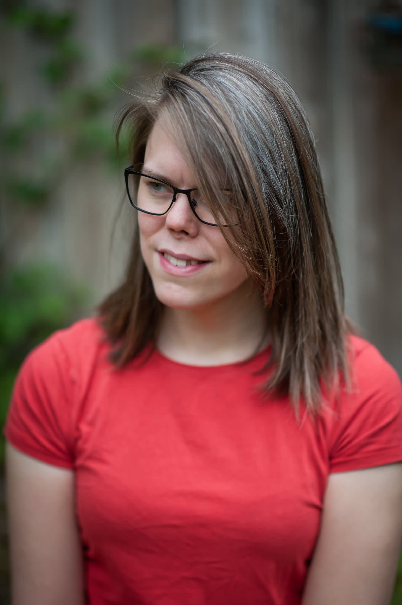 Photo of a smiling Issy Long in a red shirt.