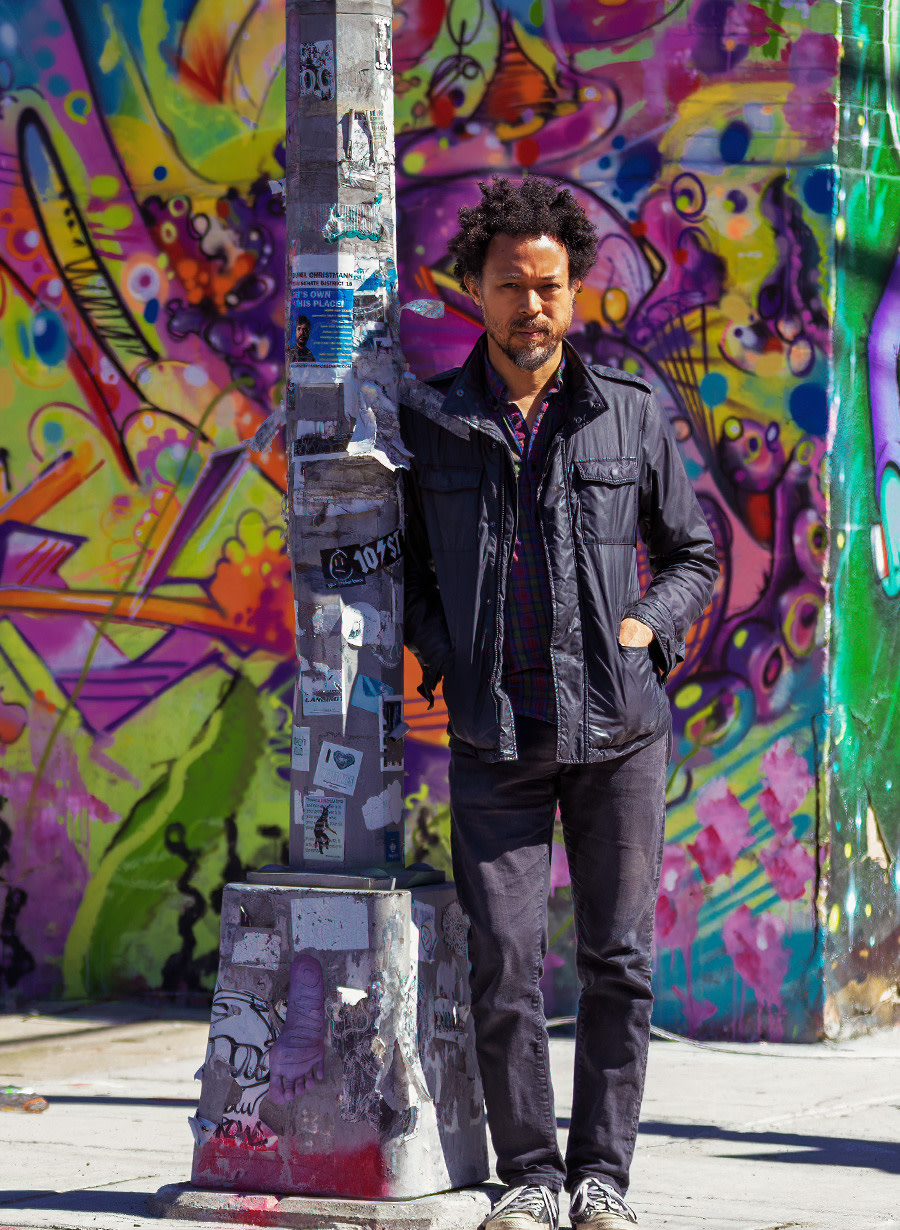 Photo of David standing in front of a colorful street mural.