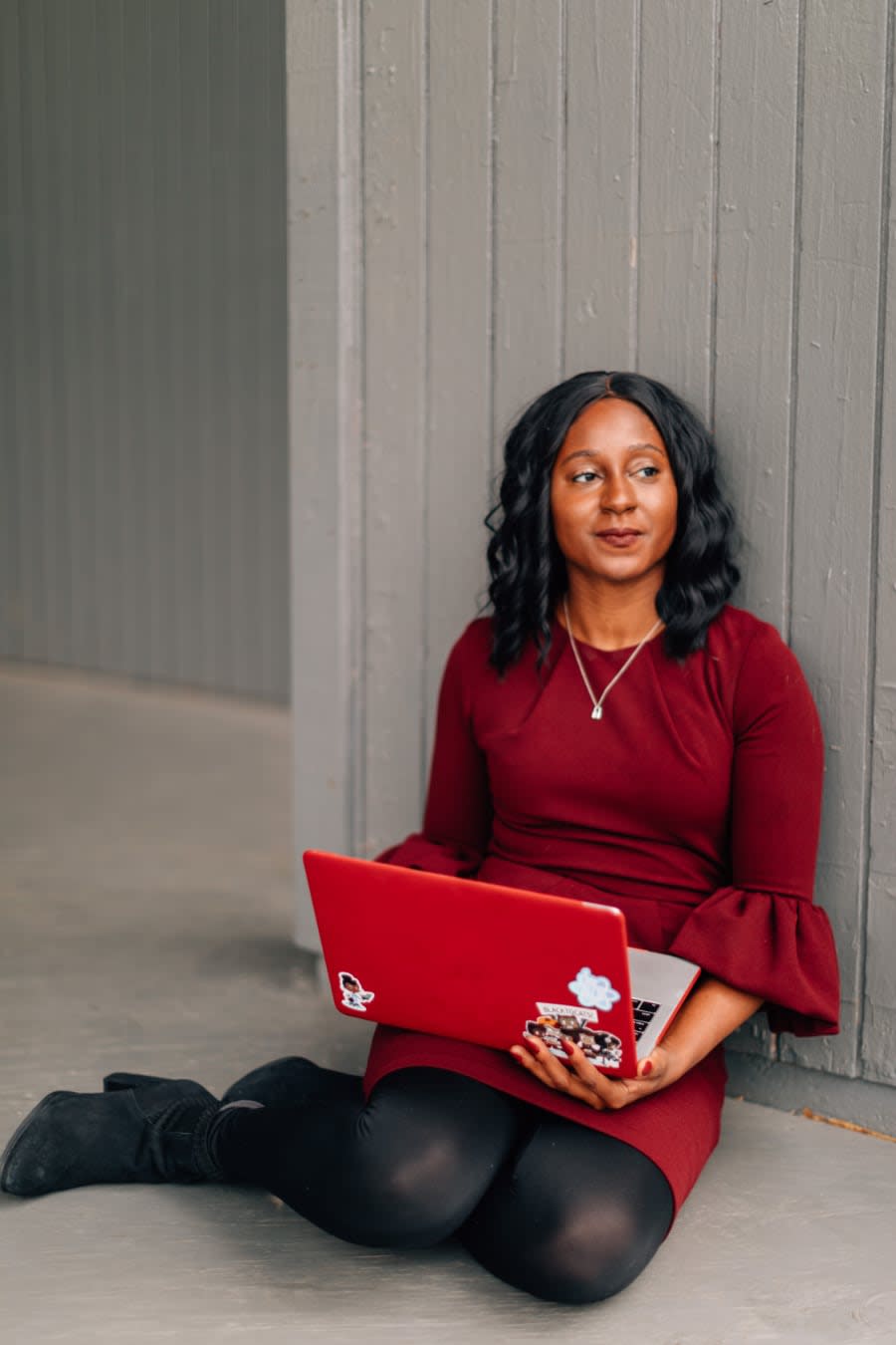 Photo of Monica Powell sitting with her laptop and contemplating.