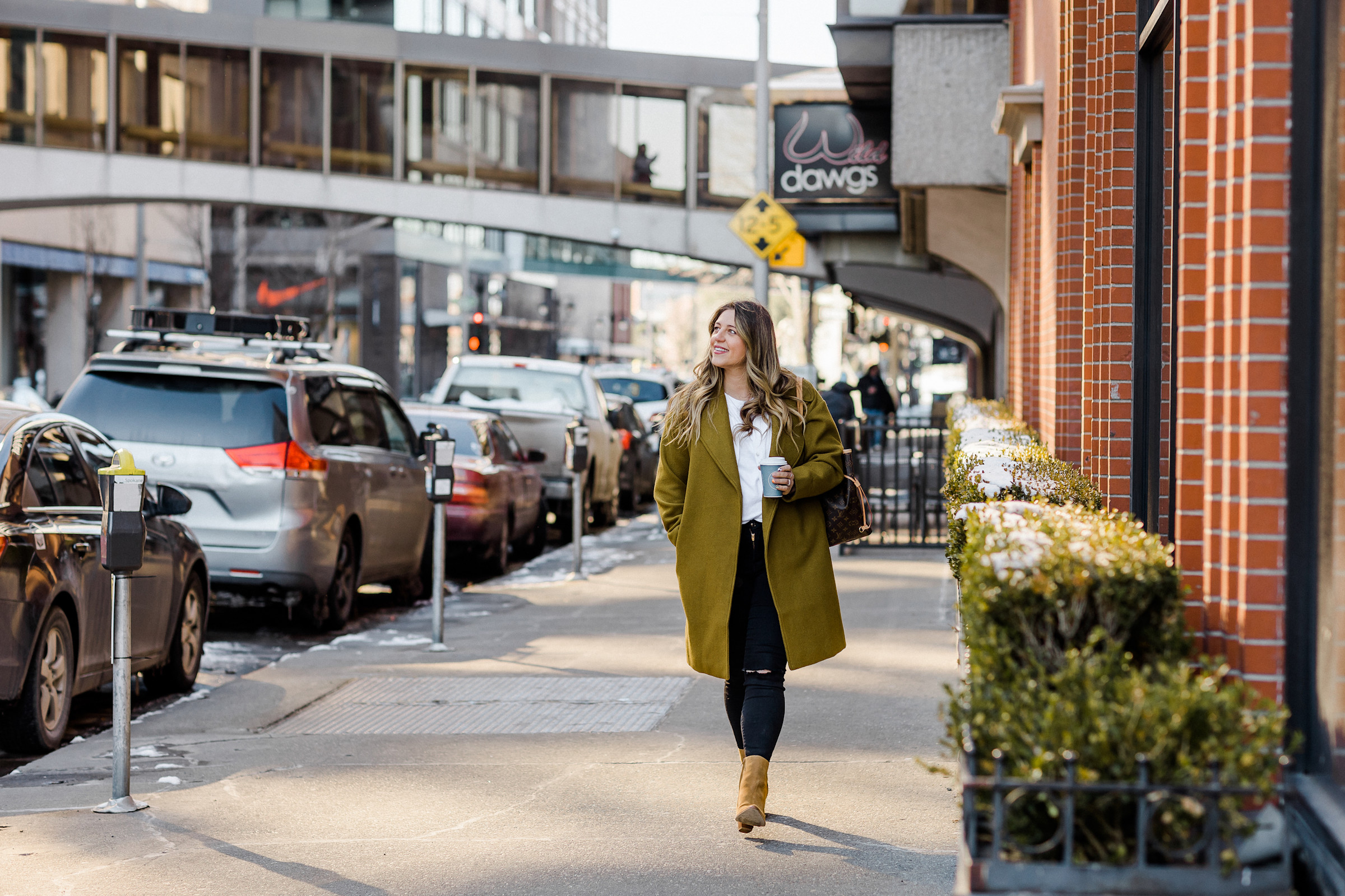 Author Rose walking down the street with a cup of coffee 