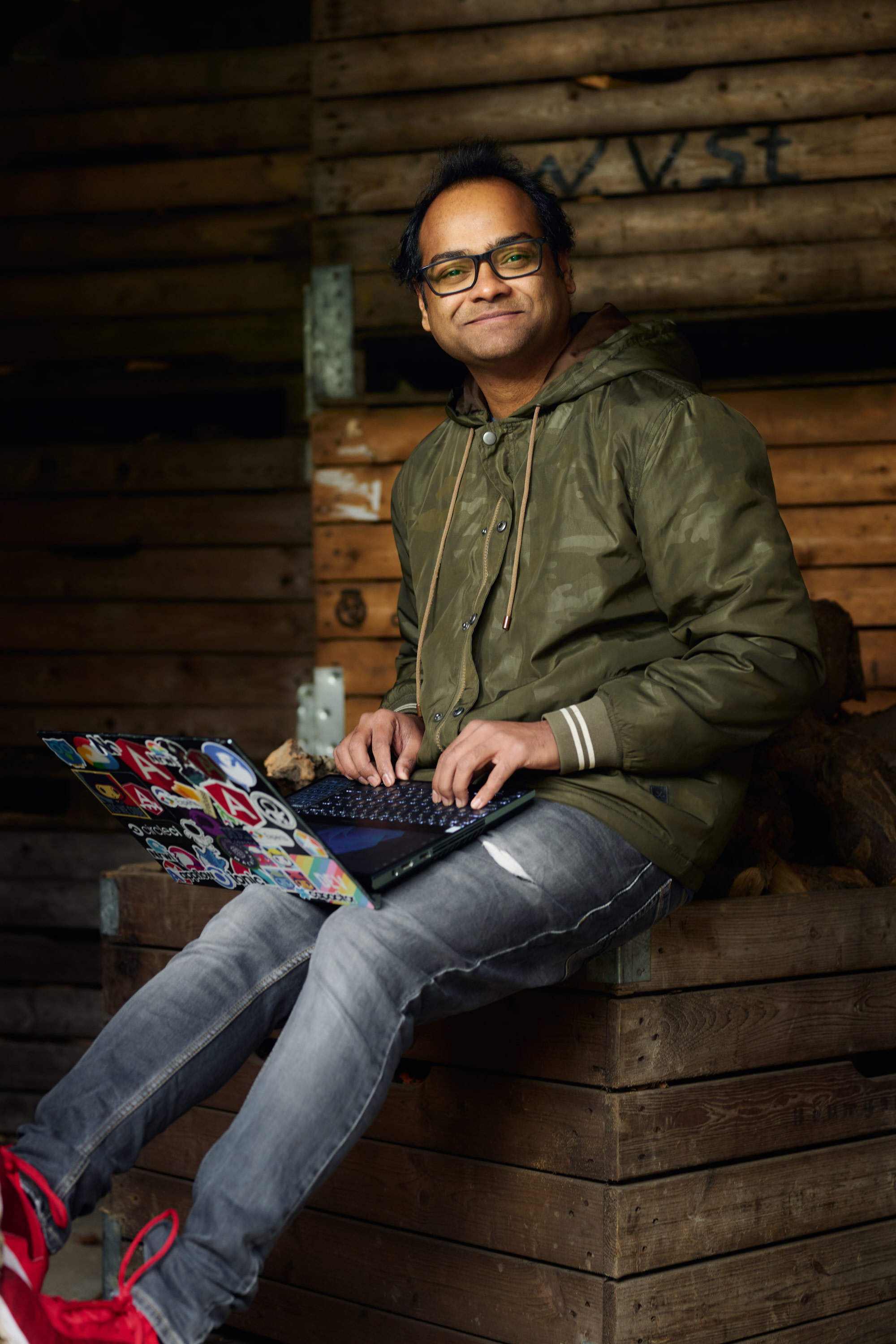 Author Santosh sitting and smiling as he works on his laptop