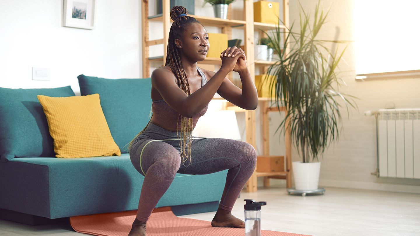 woman doing exercise squat with resistance band