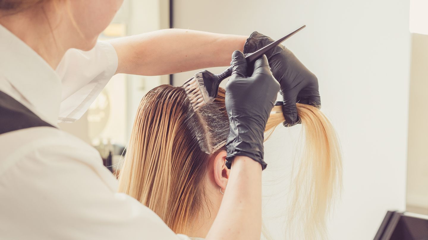 hair stylist applying bleach to hair