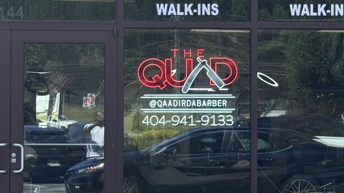 Front view of Quad Barbershop with neon sign in Mableton, Georgia, US welcoming walk-ins.