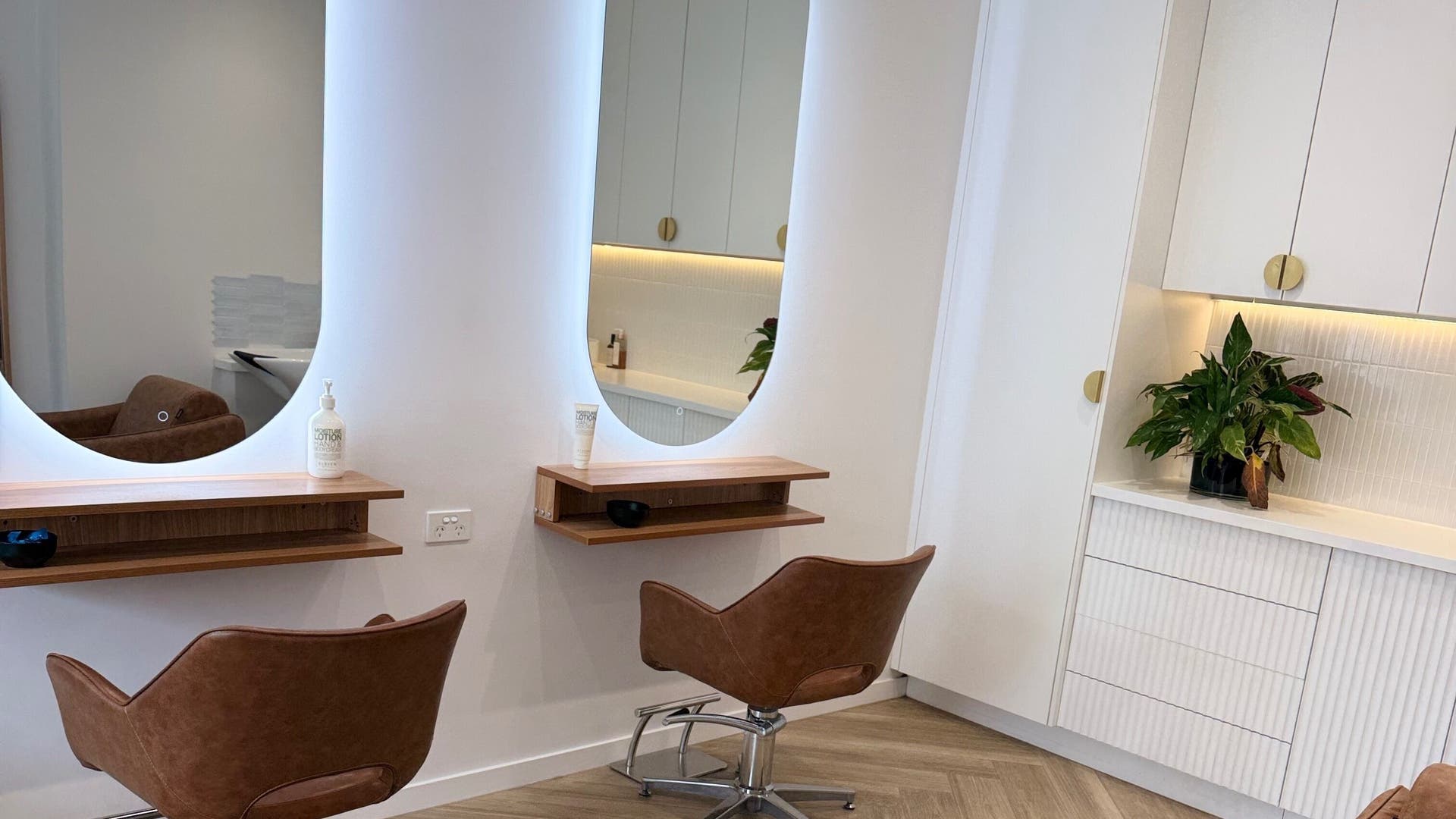 Modern salon stations with brown chairs at Hart Hair Studio, Hawthorne, Queensland, AU.