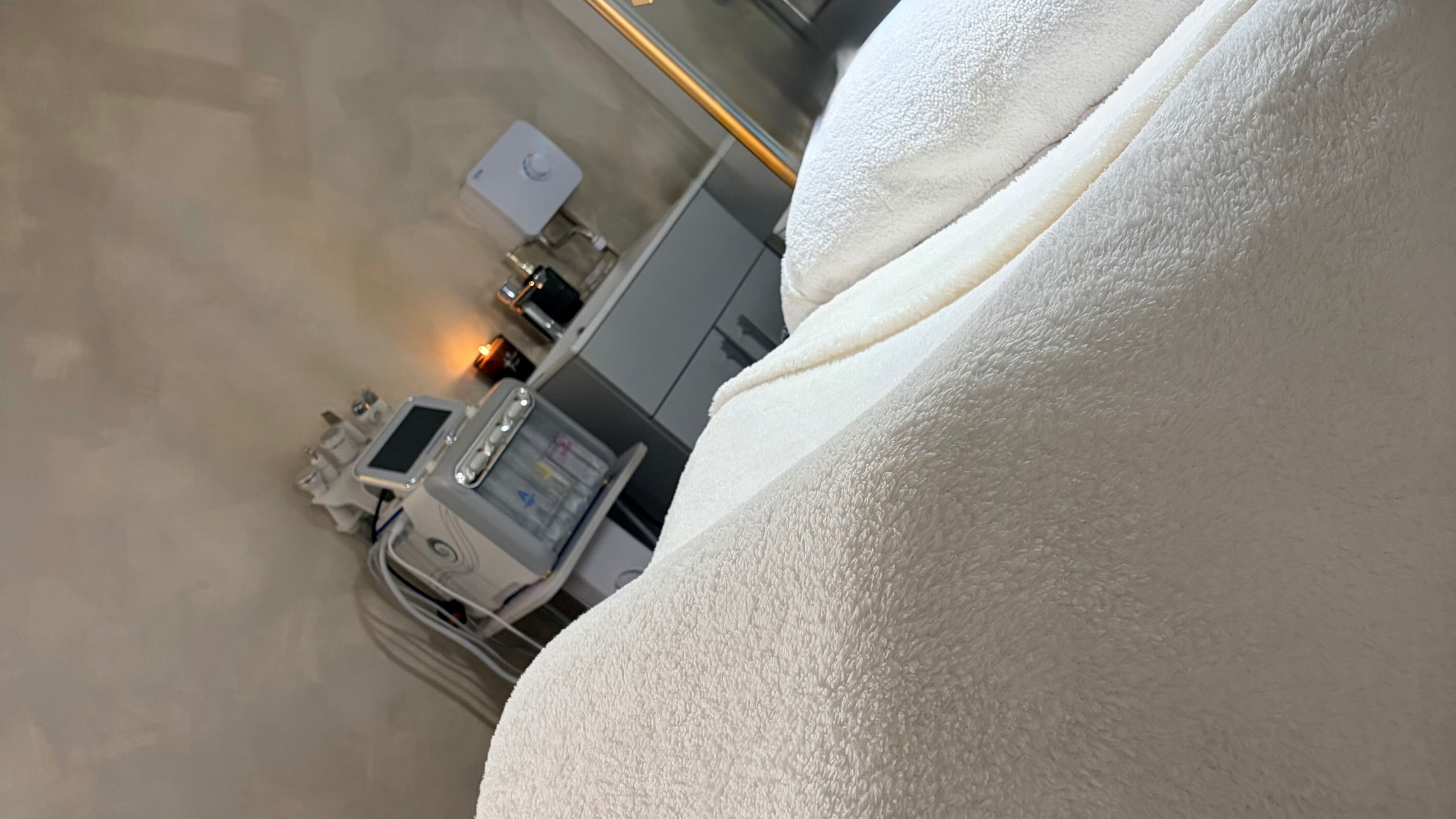 Relaxing treatment room at B’s Beauty Hive, Cardiff, Wales, GB with plush blankets and advanced spa equipment.